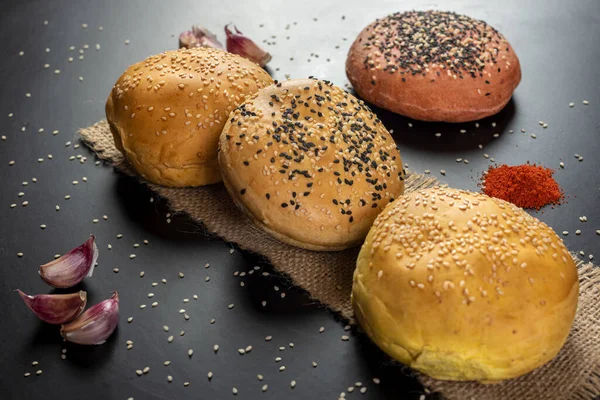 Tasty freshly baked hamburger buns with grains on a black background — Stock Image Tasty Freshly Baked Hamburger Buns Grains Black Background Stock Image