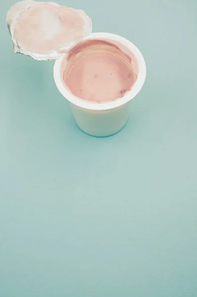 Tiro Vertical Recipiente Plástico Aberto Iogurte Frutas Uma Superfície Azul — Fotografia de Stock