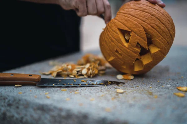 ハロウィンのためにカボチャを彫って準備する男 — ストック写真