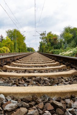 Close-up of railroad tracks leading straight forward to infinity in landscape clipart