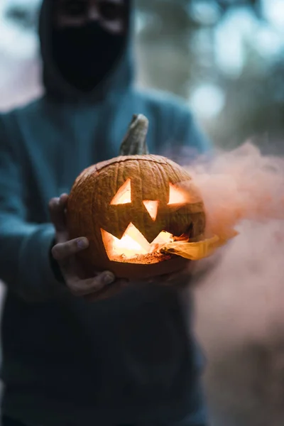 Вертикальный Снимок Человека Держащего Резную Тыкву Оранжевым Дымом Концепция Хэллоуина — стоковое фото