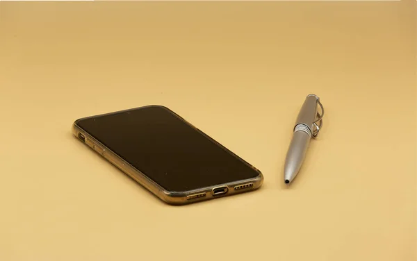 Primo Piano Uno Smartphone Nero Una Penna Sfondo Beige — Foto Stock