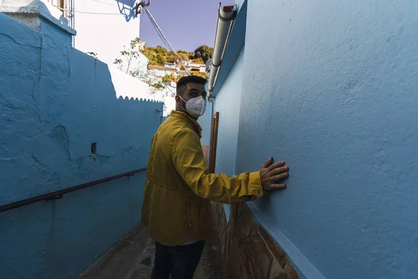 Young Male Wearing Facemask Yellow Jacket Walking Alley Blue Walls — Stock Photo, Image