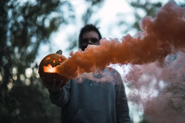 Mężczyzna Trzymający Wyrzeźbioną Dynię Pomarańczowym Dymem Wychodzącym Niej Koncepcja Halloween — Zdjęcie stockowe