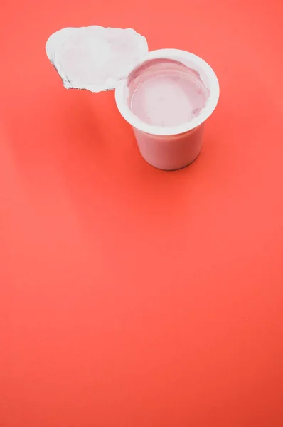 Eine Vertikale Aufnahme Eines Geöffneten Plastikbehälters Mit Fruchtjoghurt Auf Einer — Stockfoto