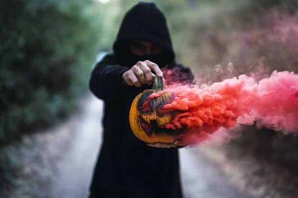 赤い煙が刻まれたカボチャを持つ男 ハロウィーンの概念 — ストック写真