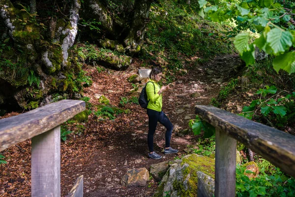 Uma Jovem Mulher Olhando Para Seu Telefone Celular Enquanto Caminhava — Fotografia de Stock