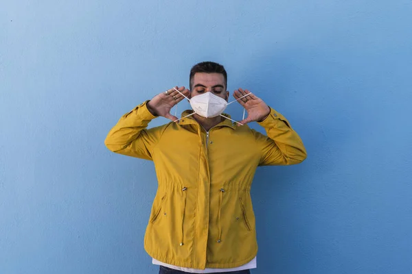 Young Male Wearing Yellow Jacket Putting Facemask Wall Covid — Stock Photo, Image