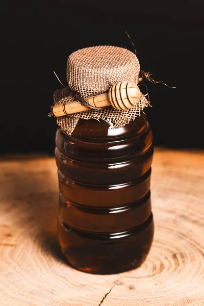 Eine Vertikale Aufnahme Eines Behälters Voller Honig Auf Einem Holztisch — Stockfoto