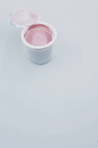Tiro Vertical Recipiente Plástico Aberto Iogurte Frutas Uma Superfície Branca — Fotografia de Stock