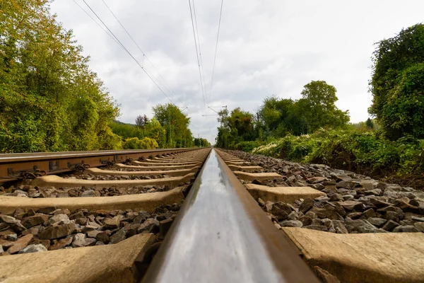 風景の中に無限にまっすぐ進む鉄道線路のクローズアップ — ストック写真