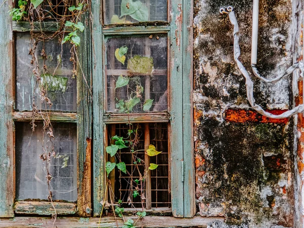 壊れたガラスと風化した壁を持つ古い窓放棄された家の外観 — ストック写真