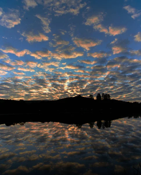 Uma Vista Hipnotizante Vertical Céu Nublado Refletindo Mar Pôr Sol — Fotografia de Stock