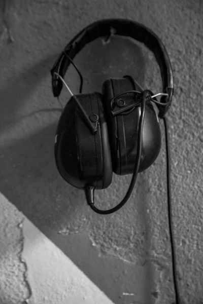 Penutupan Headphone Yang Dipasang Tergantung Dinding Beton Putih — Stok Foto