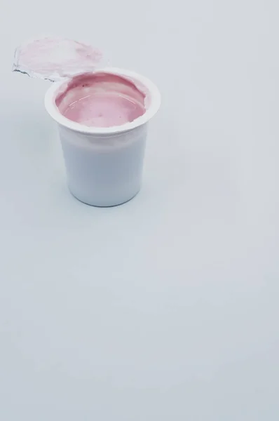 Tiro Vertical Recipiente Plástico Aberto Iogurte Frutas Uma Superfície Branca — Fotografia de Stock