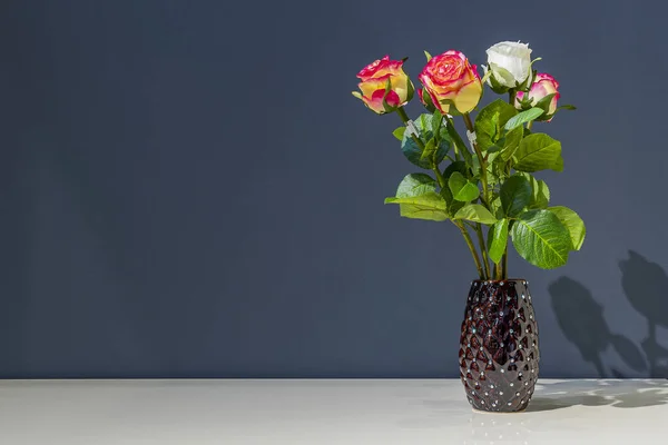 Ramo Rosas Está Jarrón Negro Sobre Una Mesa Sobre Fondo — Foto de Stock