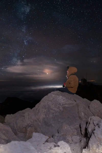 Ένας Περιπετειώδης Άντρας Κάθεται Στα Βράχια Και Κοιτάζει Τον Νυχτερινό — Φωτογραφία Αρχείου