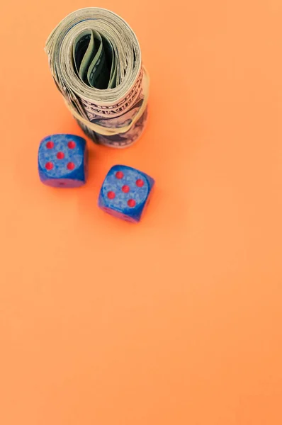 Een Bundel Opgerolde Amerikaanse Bankbiljetten Twee Blauwe Dobbelstenen Geïsoleerd Oranje — Stockfoto