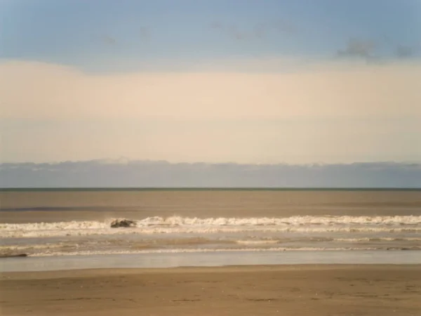 아르헨티나 해안에서 일몰시에 모래가 해변에 아름다운 파도가 — 스톡 사진