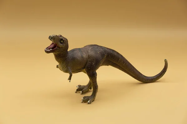 Zbliżenie Plastikowej Zabawki Dinozaura Izolowane Beżowym Tle — Zdjęcie stockowe
