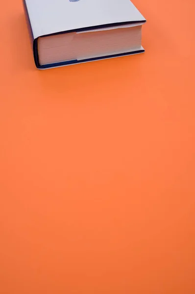Vertikale Aufnahme Eines Buches Auf Orangefarbener Oberfläche — Stockfoto