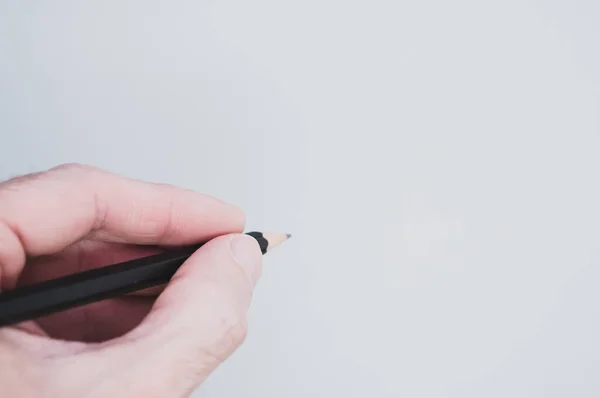 Uma Mão Segurando Lápis Preto Fundo Cinza Para Espaço Cópia — Fotografia de Stock