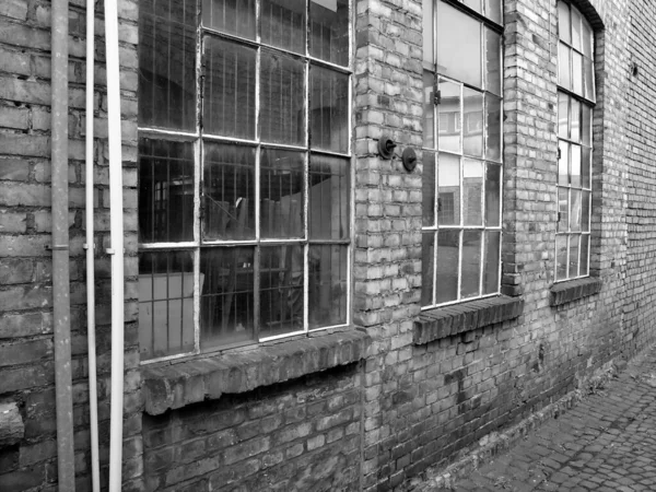 Graustufenaufnahme Eines Alten Backsteingebäudes Mit Glasfenstern — Stockfoto