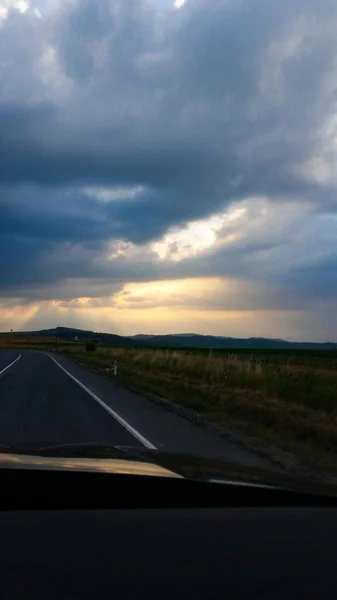 시골과 구름낀 하늘을 가로지르는 도로를 수직으로 — 스톡 사진