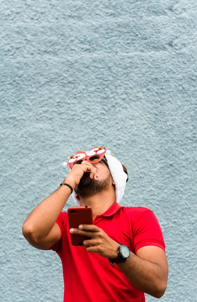 Plano Vertical Latino Con Sombrero Navidad Gafas Mirando Teléfono Riendo — Foto de Stock