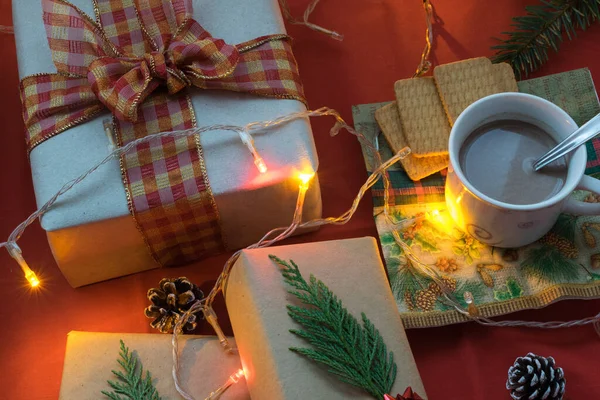 Ein Weihnachtsgeschenk Mit Lichtern Neben Einer Tasse Milch Mit Plätzchen — Stockfoto