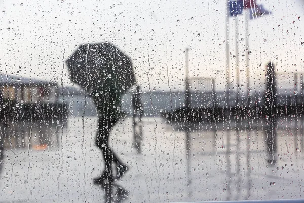 Wybiórcze Ujęcie Mokrym Oknem Widokiem Osoby Parasolem Spacerujące Deszczowy Dzień — Zdjęcie stockowe