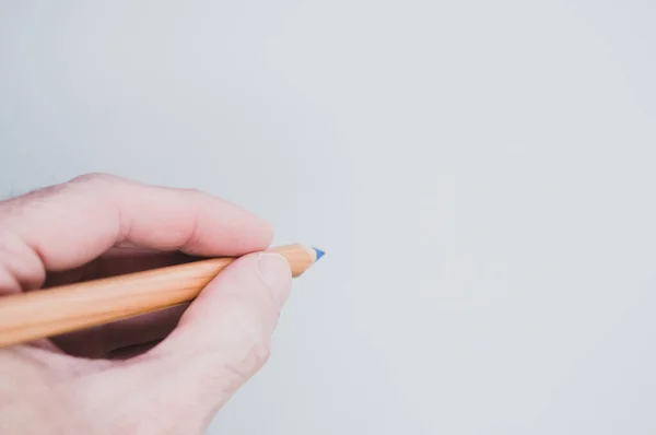 Una Mano Sosteniendo Lápiz Azul Sobre Fondo Gris Para Espacio —  Fotos de Stock