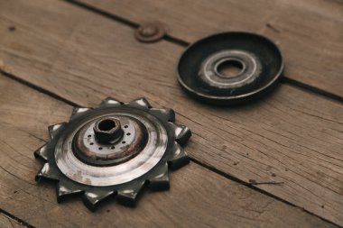 A closeup of greasy bicycle sprocket on a wooden floor clipart