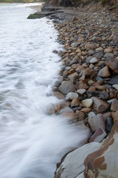 在海滩上 一道纵横的海浪拍打在石头上 — 图库照片