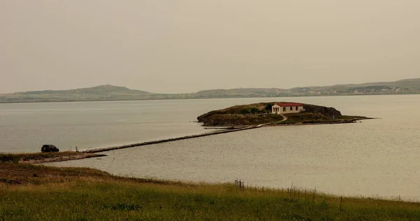 人里離れた島の家と海岸を結ぶ石造りの桟橋 — ストック写真