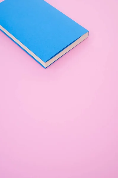 ピンクの表面に青いハードカバーの本の閉鎖 テキストのためのスペース — ストック写真