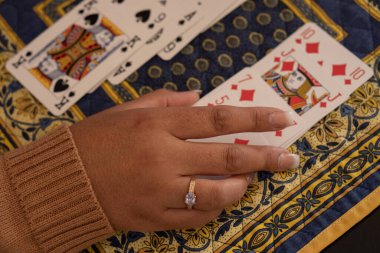 SANTA MARIA CAPUA, ITALY - Oct 18, 2020: Santa Maria Capua Vetere, Italy, October 18th 2020, The hands of a woman playing Rummy at home clipart