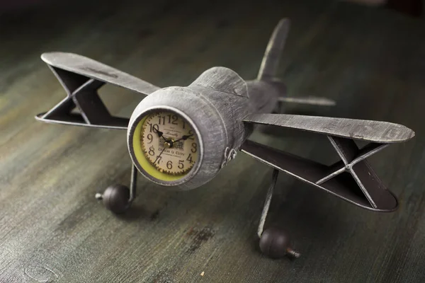 在木制表面拍摄的一个古代风格的飞机时钟的特写 — 图库照片