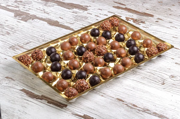Tahta Bir Yüzeyde Altın Kaplama Tepside Yakın Plan Bir Çikolata — Stok fotoğraf