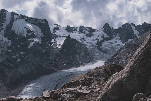 曇り空の下で雪に覆われた険しい山脈の素晴らしいショット — ストック写真