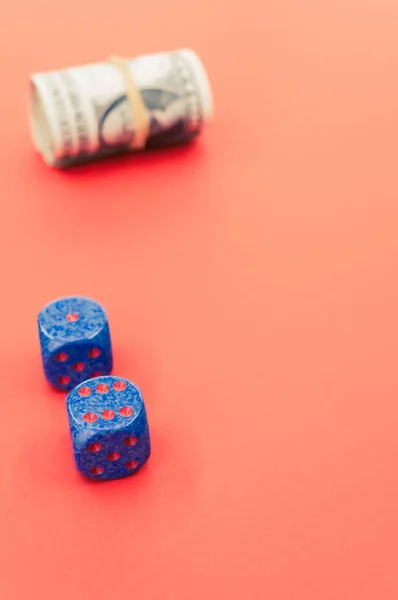 两张蓝色骰子的选择性焦点镜头 用粉红背景隔离的纸包纸钞票 — 图库照片