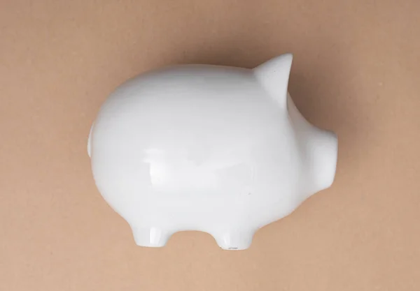 ベージュの背景に白い貯金箱のクローズアップショット 節約の概念 — ストック写真