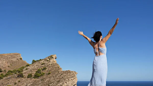 一个年轻女性高举双手享受自由的回顾 — 图库照片
