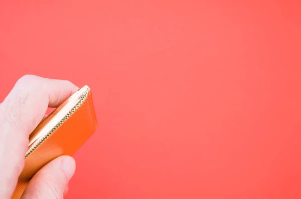 Close Uma Mão Segurando Saco Miniatura Ouro Isolado Fundo Vermelho — Fotografia de Stock