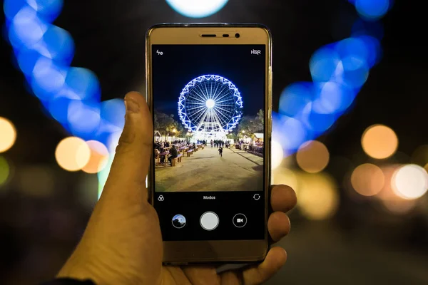 Ένα Χέρι Που Κρατάει Ένα Smartphone Και Φωτογραφίζει Έναν Τροχό — Φωτογραφία Αρχείου