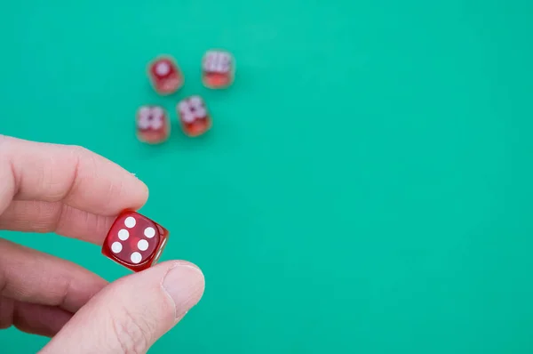 骰子在孤立的绿色背景上手握骰子的人的高角镜头 — 图库照片