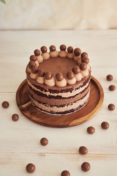 Вертикальный Снимок Вкусного Шоколадного Торта Шоколадными Шариками Сливками Белом Столе — стоковое фото