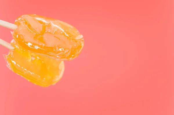 Zbliżenie Strzał Pomarańczowe Lizaki Odizolowane Różowym Tle — Zdjęcie stockowe