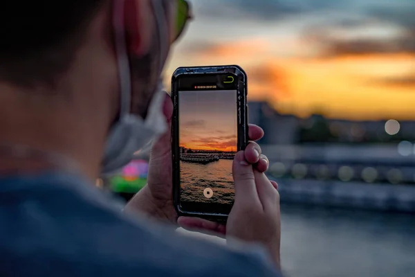 携帯電話に夕日を記録している人のクローズアップ — ストック写真