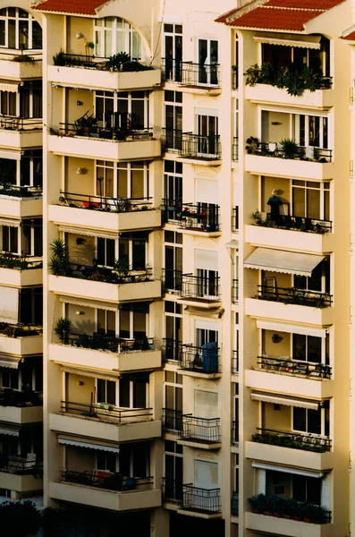 太陽の下で植物で飾られたバルコニー付きのアパートの建物の垂直ショット — ストック写真